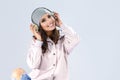 Girl in Pink Hoodie Listening to Music in Headphones. Against Gray.