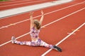 A girl in a legging doing splits at the stadium