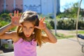 Girl in pink outfit smiling making plauful gesture Royalty Free Stock Photo