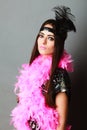 Girl pink plume and black feather on head. Carnival. Royalty Free Stock Photo