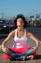 Girl in pink skirt meditates on highway middle