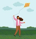 Girl playing with kite in windy weather on green plain. Strong wind, cloudy. Girl launches a kite