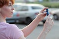 Girl in pink t-shirt is playing blue metal spinner in hands on the street, woman playing with a popular fidget spinner toy, anxiet