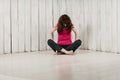 A girl in a pink top, sitting cross-legged on the floor, light b Royalty Free Stock Photo