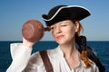 The girl-pirate looks in a jug against the sea Royalty Free Stock Photo