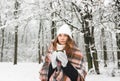 A girl in a plaid drinks tea in winter