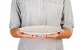 Girl in the plaid shirt is holding an empty round white plate in front of her. woman hand hold empty dish for you desing. perspect Royalty Free Stock Photo