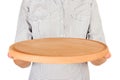 Girl in the plaid shirt is holding an wooden empty round plate for pizza in front of her. woman hand hold empty dish for you desin Royalty Free Stock Photo