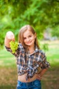 Girl in a plaid shirt and jeans holding a bunch of green grapes close-up. Concept of harvesting a plantation of grapes and a girl Royalty Free Stock Photo