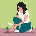 The girl planted a young seedling in the ground