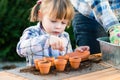 Girl planting flower seeds into pots with her mother Royalty Free Stock Photo