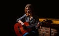 Girl play the guitar. Woman hipster man sitting in a pub. Woman playing guitar, holding an acoustic guitar in his hands Royalty Free Stock Photo