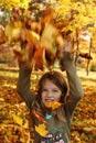 Girl playing with autumn leaves up in the air Royalty Free Stock Photo