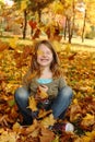 Girl playing with autumn leaves up in the air Royalty Free Stock Photo