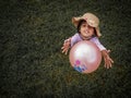A girl playing ball with green grass background. Royalty Free Stock Photo