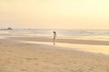 Girl playing on beach at sunset.