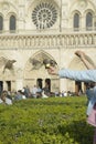 Girl playing with birds in the park next to Notre Dame Cathedral, Paris, France Royalty Free Stock Photo