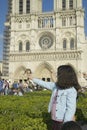 Girl playing with birds in the park next to Notre Dame Cathedral, Paris, France Royalty Free Stock Photo