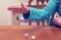 A girl playing a board game and rolls dice. Hand throws the dice on the background of colorful blurred fantasy Board games, gaming Royalty Free Stock Photo