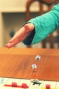 A girl playing a board game and rolls dice. Hand throws the dice on the background of colorful blurred fantasy Board games, gaming Royalty Free Stock Photo