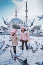 girl playing and chasing pigeons in city square Royalty Free Stock Photo