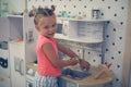 Girl playing in children kitchen.