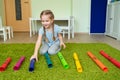 Girl playing with colourful musical tubes.