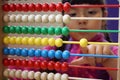 Girl playing with colourful wooden abacus