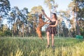 Girl playing with a dog in a park against trees background. The dog jumps to the girl`s hands Royalty Free Stock Photo