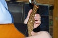 The girl is playing dombra and beating the chords on the guitar, close-up.