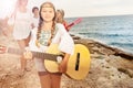 Girl playing guitar for her friends on the beach Royalty Free Stock Photo