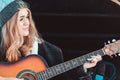 Girl playing guitar sitting on car trunk Royalty Free Stock Photo