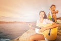 Girl playing guitar to her friend on the beach Royalty Free Stock Photo