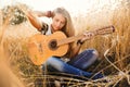 Girl playing the guitar in a wheat field Royalty Free Stock Photo