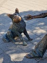 A girl playing with her Dog statue within the cityscape of Budapest