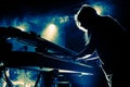 Girl playing keyboards during concert, silhouette