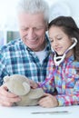 girl playing nurse, inspecting teddy bear