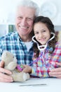 girl playing nurse, inspecting teddy bear