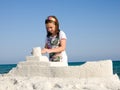 Girl playing by ocean sculpturing boat Royalty Free Stock Photo