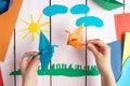 A girl is playing with an origami crane made of paper that she made herself. On a wooden background Royalty Free Stock Photo