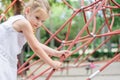 Girl playing in the park. Little girl climbing on outdoor playg