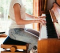 Girl is playing piano at home, high angle view, blurry background