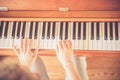 Girl is playing piano at home, high angle view, blurry background
