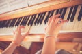 Girl is playing piano at home, high angle view, blurry background