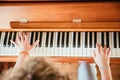 Girl is playing piano at home, high angle view, blurry background