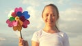 Girl playing pinwheel park in slow motion. Happy child playing having fun pinwheel. Happiness vacation childhood