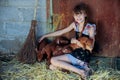 The girl is playing with red newborn pigs of the Duroc breed. The concept of caring and caring for animals Royalty Free Stock Photo