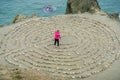 Girl playing in a rock maze; Water in the background