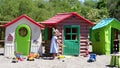 A girl is playing in the sand in front of a row of playhouses
