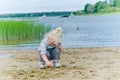 Girl playing in the sand on shore of Lake Royalty Free Stock Photo